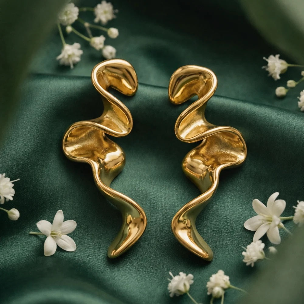 Sculptural gold-filled swirl drop earrings on green silk